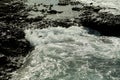 Beautiful grey sea stormy waves splash against black stony shore Royalty Free Stock Photo