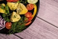 Beautiful grilled sausages on a black plate with vegetables and a background of boards