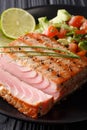 Beautiful grilled tuna fillet with lime and avocado salsa closeup. vertical
