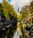 Beautiful canal in Amsterdam with the Soutern church Zuiderkerk at sunset in Fall