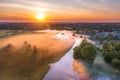 Beautiful ground fog over a small river among grassy meadows in rural areas, early in the morning at dawn