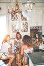 Beautiful group of women sitting at kitchen drinking cup of coffee speaking and smiling Royalty Free Stock Photo