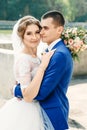 Beautiful guy and girl, bride in a white wedding dress, groom in a classic blue suit against a nature background. Wedding, family Royalty Free Stock Photo