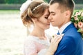 Beautiful guy and girl, bride in a white wedding dress, groom in a classic blue suit against a nature background. Wedding, family Royalty Free Stock Photo