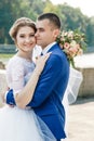 Beautiful guy and girl, bride in a white wedding dress, groom in a classic blue suit against a nature background. Wedding, family Royalty Free Stock Photo