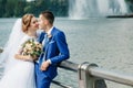 Beautiful guy and girl, bride in a white wedding dress, groom in a classic blue suit against a nature background. Wedding, family Royalty Free Stock Photo