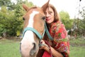 Beautiful gypsy girl in bright clothes with a horse on a farm Royalty Free Stock Photo