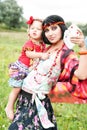 Beautiful gypsy girl in a red dress with the baby Royalty Free Stock Photo