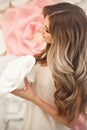 Beautiful hair. Woman beauty portrait smiling with makeup and long healthy hairstyle over pink white roses flowers Royalty Free Stock Photo