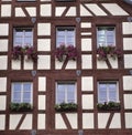 Beautiful half-timbered white house with red geraniums on the windowsill