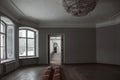 A beautiful hall with a chandelier and windows in an old abandoned manor house.