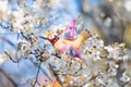 Beautiful hand made colorful bird hanging on a blooming cherry tree at spring Easter day Royalty Free Stock Photo