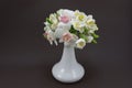 Hand made polymer clay bouquet in a white vase on a dark background