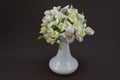 Hand made polymer clay bouquet in a white vase on a dark background