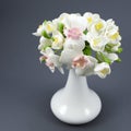 Hand made polymer clay flower bouquet in a white vase on a gray