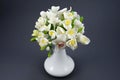 Hand made polymer clay flower bouquet in a white vase on a gray