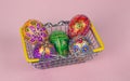 Beautiful hand painted Easter eggs in a basket from the supermarket on a pink background Royalty Free Stock Photo