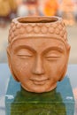 Beautiful handmade statuette of a Buddha head is displayed in a shop for sale in blurred background. Indian art and handicraft