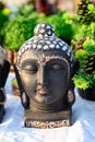 Beautiful handmade statuette of a Buddha head is displayed in a shop for sale in blurred background. Indian art and handicraft