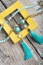 Beautiful handmade  turquoise  jewelry with natural gems in yellow box around old style wooden background. close up. fashion Royalty Free Stock Photo