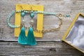 Beautiful handmade  turquoise  jewelry with natural gems in yellow box around old style wooden background. close up. fashion Royalty Free Stock Photo