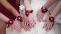 Beautiful hands of the bride and bridesmaids. wedding party. girls hands are decorated with red flowers. fashion girls Royalty Free Stock Photo