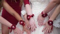 Beautiful hands of the bride and bridesmaids. wedding party. girls hands are decorated with red flowers. fashion girls Royalty Free Stock Photo