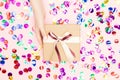 Beautiful hands girl hold giveaway gift box present craft paper on pink confetti background. Concept Christmas, New Year