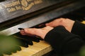 Beautiful hands with long fingers of a girl with black varnished nails playing piano