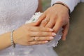 Beautiful hands of newlyweds with engagement rings lie on each other under them a wedding bouquet Royalty Free Stock Photo