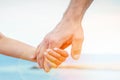 Beautiful hands of parent and child on sea background Royalty Free Stock Photo