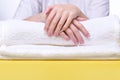 Beautiful hands of young woman close-up on towel. Spa treatments for nails. Space for text. Royalty Free Stock Photo