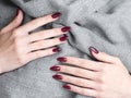 Hands of a young woman with dark red manicure on nails Royalty Free Stock Photo