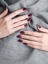 Hands of a young woman with dark red manicure on nails Royalty Free Stock Photo