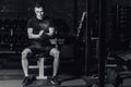 Beautiful handsome young athlete dressed in black t-shirt. During this time, sitting on the tires and applying talcum to Royalty Free Stock Photo