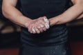 Beautiful handsome young athlete dressed in black t-shirt. During this time, sitting on the tires and applying talcum to Royalty Free Stock Photo