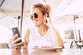 Beautiful and happy adult model woman use modern cellular phone at the restaurant with wifi connection - cheerful people and Royalty Free Stock Photo