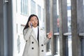 Beautiful and happy asian woman talking on the phone, chinese woman walking during a break near the office, business woman Royalty Free Stock Photo