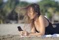 Beautiful and happy Asian woman using mobile phone texting on internet social media smiling relaxed Royalty Free Stock Photo