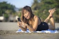 Beautiful and happy Asian woman using mobile phone texting on internet social media smiling relaxed Royalty Free Stock Photo