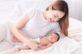 Beautiful happy Asian women mom kissing healthy toddler newborn baby in bed at home, Healthcare medical lifestyle mother`s day/ Royalty Free Stock Photo