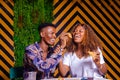 Beautiful happy black couple enjoying eating pizza and drink in a cafe Royalty Free Stock Photo