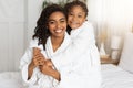 Beautiful Happy Black Mom And Daughter Posing On Bed In White Bathrobes Royalty Free Stock Photo