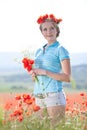 Beautiful blond woman in field with poppies Royalty Free Stock Photo