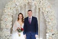 beautiful and happy bride and groom in an arch of flowers at wedding ceremony Royalty Free Stock Photo