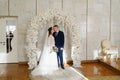 beautiful and happy bride and groom in an arch of flowers at wedding ceremony Royalty Free Stock Photo