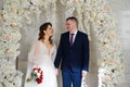 beautiful and happy bride and groom in an arch of flowers at wedding ceremony Royalty Free Stock Photo