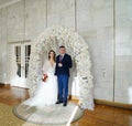 beautiful and happy bride and groom in an arch of flowers at wedding ceremony Royalty Free Stock Photo