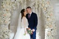 beautiful and happy bride and groom in an arch of flowers at wedding ceremony Royalty Free Stock Photo