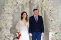 beautiful and happy bride and groom in an arch of flowers at wedding ceremony Royalty Free Stock Photo